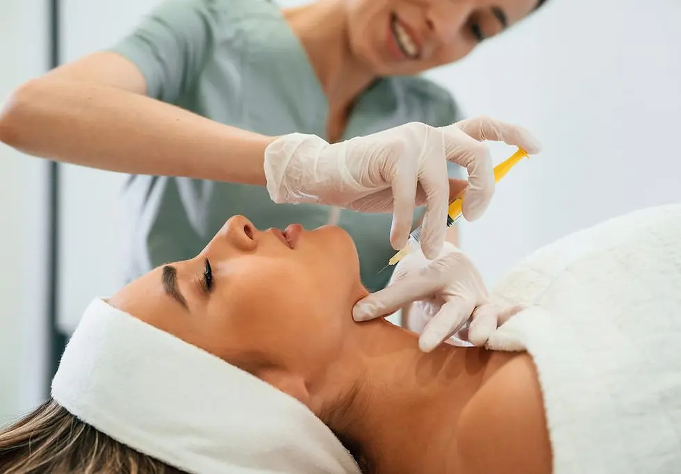 أخصائية بقفازات تطبّق سيرومًا على خدّ وعنق مريضة بجهاز على شكل قلم